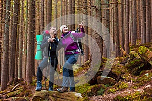 Man and Woman Hikers Staying in Dense Old Forest Smiling and Pointing