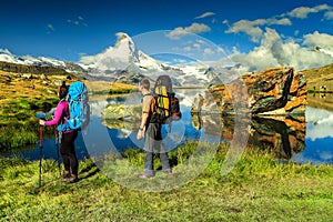 Man and woman hikers trekking in mountains, Valais, Zermatt, Switzerland