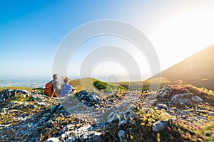 Man and woman hiking in the mountains of Umbria region, Monte Cucco, Appennino, Italy. Couple watching sunset together on mountain