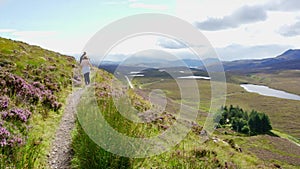 A man and a woman hiking through the Scottish mountains in an idyllic landscape, Scotland, UK.