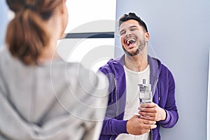 Man and woman hoilding bottle of water standing at sport center