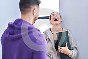 Man and woman hoilding yoga mat standing at sport center