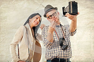 Man and woman hold retro camera. Texture background