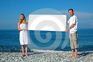 Man and woman holding blank billboard
