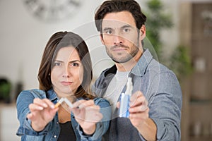 man and woman holding broken cigarette and vaping machine