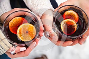 Man and woman holding glass of mulled wine with spices