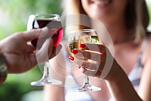 Man and a woman are holding glasses of red and white wine.