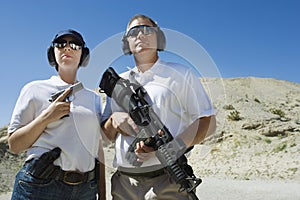 Man And Woman Holding Guns At Firing Range