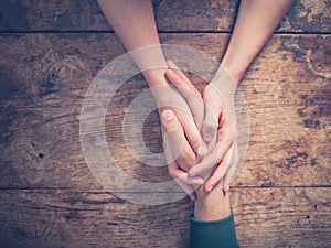 Man and woman holding hands at a table