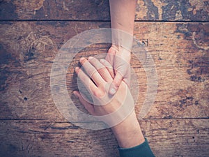 Man and woman holding hands at a table