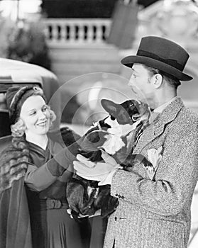 Man and woman holding a little dog