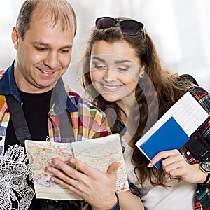 Man and a woman holding a passport .Look at the map, direction of study. Europeans. Gathered in a guided tour.Honeymoon