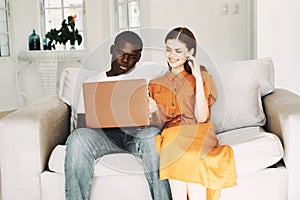 man and woman at home on the couch with laptop communication leisure