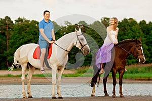 Man and woman with a horses at the sea. Romantic love.