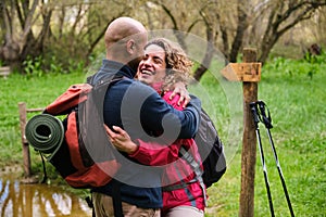 A man and woman hug each other in a forest.