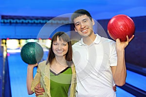 Man and woman hug and in free hand hold ball