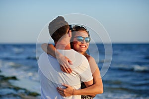 Man and woman hugging in the background of sea and sky.