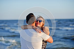 Man and woman hugging in the background of sea and sky.