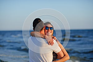 Man and woman hugging in the background of sea and sky.
