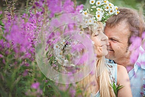 Man and a woman hugging in flower field.
