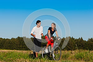 Man and woman jogging and with bicycle