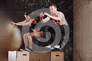 Man and woman jumping on fit box photo