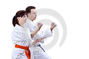 Man and woman in karategi stand in the rack karate