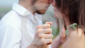 Man and woman kiss with baptized hands on blurred background