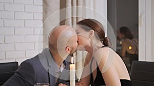 A man and a woman kiss on a date. Young couple on a date in a restaurant
