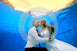 Man and woman kissing underwater in the swimming pool