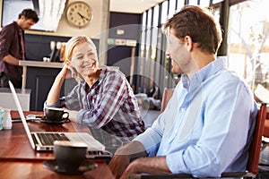 Man and woman with laptop at a coffee shop