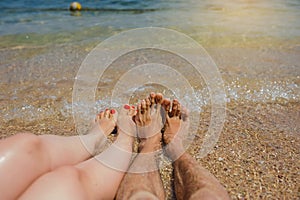 man and woman legs on the beach