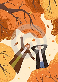 man and woman lie under autumn trees. card with a couple lying on the ground, top view. Husband and wife are resting in the autumn
