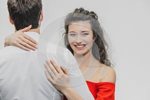 Man and woman with long hair. The wife hugged her husband. Back view. Valentine`s Day. I Woman dressed in red man dress