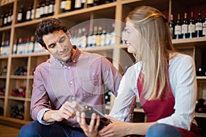 man and woman looking at bottle wine