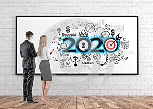 Man and woman looking at 2020 business sketch