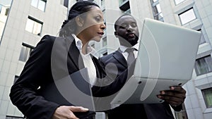 Man and woman looking at laptop outside building, attorneys, brand new evidence