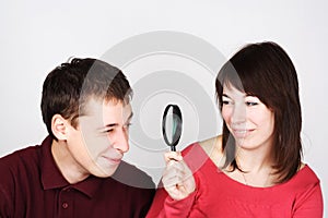 Man and woman looking through magnifier photo
