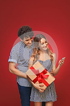 Man and woman looking at the phone with a gift in style Pin Up i