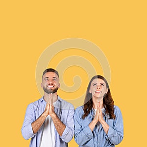 Man and woman looking up with hopeful expressions