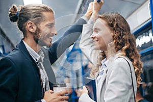 man and woman in love looking at each other on a subway train.