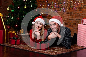 Man and woman lying near the Christmas tree