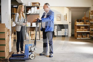 Man, woman and management in distribution warehouse, supply chain and logistics industry with pallet jack for boxes