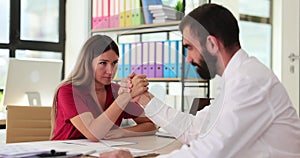 Man and woman manager and hand wrestling in office