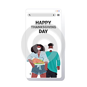 Man woman in masks celebrating happy thanksgiving day african american couple holding roasted turkey coronavirus