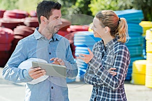 man and woman in materials yard holding tablet