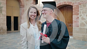 Man and woman mother and son hugging each other celebrating graduation at university