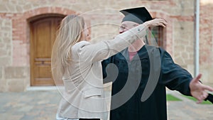 Man and woman mother and son hugging each other celebrating graduation at university