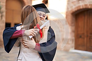 Man and woman mother and son hugging each other celebrating graduation at university