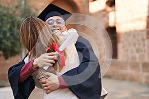 Man and woman mother and son hugging each other celebrating graduation at university